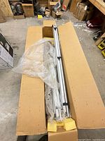 Box opened showing packed aluminum door components and tracks