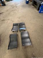 four black steel rolling dollies on shop floor