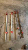 Four steel pipe bar clamps laid on floor