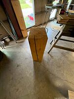 Full view of vertical timber post standing on concrete floor