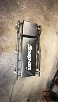 Full view of folded Snap-on creeper showing logo and frame