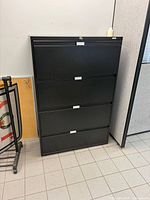Front view of black four-drawer lateral file cabinet