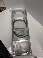 Sealed package showing four chrome light housings, label, and gaskets