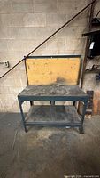 Full view of workbench showing pegboard back, top, frame and lower shelf