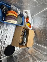 Polisher in box, pads in bin and bag