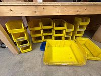 Stacked yellow and blue plastic bins under workbench