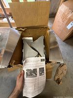 Box opened showing wheel chock, mounting holders and instruction manual