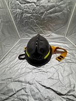 Front view of black firefighter helmet with yellow reflective strip and Nomex neck cover