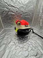 Front angled view showing visor, red crown, off-white shell and flashlight