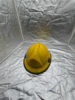 Top view of yellow firefighter helmet showing crest and shell condition