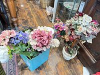 Overall lot showing tote of stems, potted arrangement and pedestal bouquet