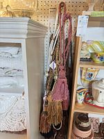 Bundle of multiple curtain tassel tiebacks hanging on pegboard