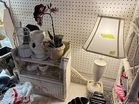 Overall view of lamp, wicker shelf, top decor items