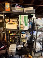 Overall view of shelving with paper towel box, bins, baskets, cloth tub, zipper bags, tarp package likely on shelf