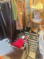 overall view showing hanging garments, plastic bin of clothes, and metal display rack