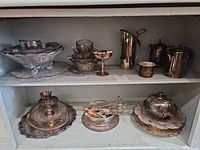 overview of hollowware and trays on cabinet shelves