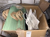 Box showing green and white paper gift bags in bulk