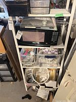 Front view showing five mesh shelves and contents for scale
