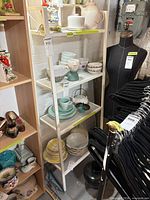 Full view of white metal shelving unit with contents shown for scale