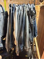 Rack of multiple denim garments on hangers