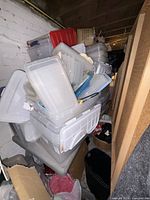 Stack of various clear and colored plastic bins and lids