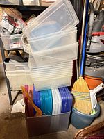 stack of clear plastic bins, metal mesh bin with colored lids visible