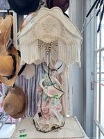 Full view of porcelain figural lamp with fabric shade showing overall design and height