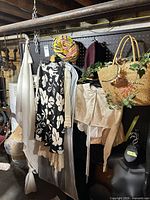 Overall lot showing dresses, hats, straw bag, blouse on pegboard