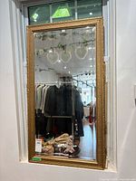 Full view of gilded rectangular mirror hung on wall