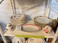 Stacks of plates, two platters and two scent eggs on shelf