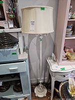 Full view of cream floor lamp beside furniture