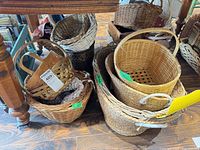 Group of assorted wicker baskets under table