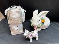 Group shot of rabbit, cow planter, and two boxed pig figurines