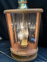 Full view of lamp showing wood base, glass panels, brass neck