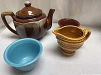 Group shot of teapot, creamer, two ramekins
