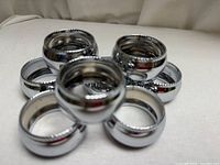 front view of eight convex stainless steel napkin rings arranged in cluster