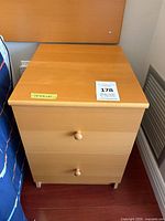 Front view of light wood two-drawer bedside table