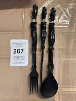 Three ebony wood utensils with lot tag visible