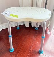 Full view of AquaSense shower chair showing seat surface, adjustable legs and feet