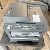 Front and top view of Brother MFC-7460DN printer showing control panel, flatbed scanner and paper tray