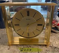 Front view of Bulova brushed brass mantel clock showing dial and frame