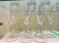 Front view of all champagne flutes aligned on shelf