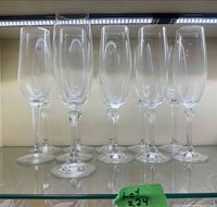 Front view of all 11 clear champagne flutes on shelf