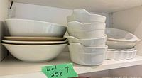 Stacked shallow bowls and handled bowls, pie dish partially visible