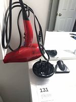 Hair dryer hanging with cord, diffuser and nozzle visible
