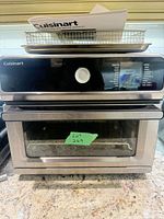 Front view of Cuisinart air fryer toaster oven with basket, pan, manual