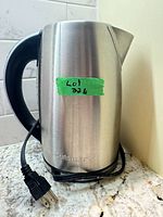 Side view of stainless steel Cuisinart electric kettle with power cord