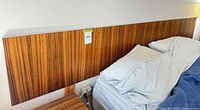 Front view of zebrawood veneer headboard behind bed