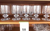 Seven Iittala Senator goblets on shelf front view