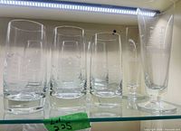 Six highball glasses and two pilsner glasses on shelf